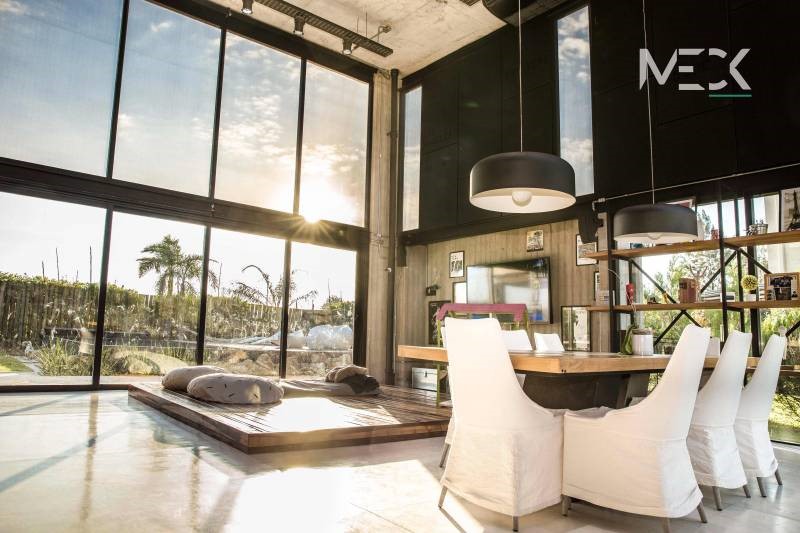 Interior de doble altura con vista al jardín